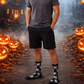 Person standing in a Halloween-themed setting with pumpkins and a misty background