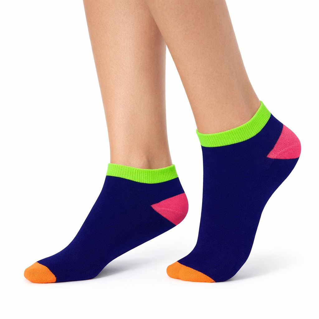 Colorful socks with green cuffs and pink and orange toes worn by a person on a white background