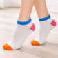 White Ankle socks with colorful accents on a light wooden floor