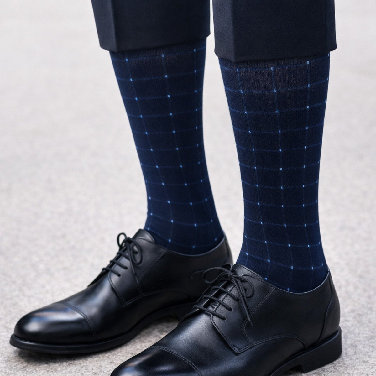 Navy blue checkered Dr. Motion Compression socks with black dress shoes on a neutral background
