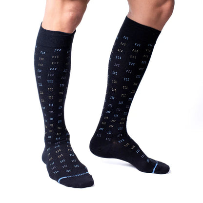 Black knee-high socks with blue pattern worn by a person on a white background